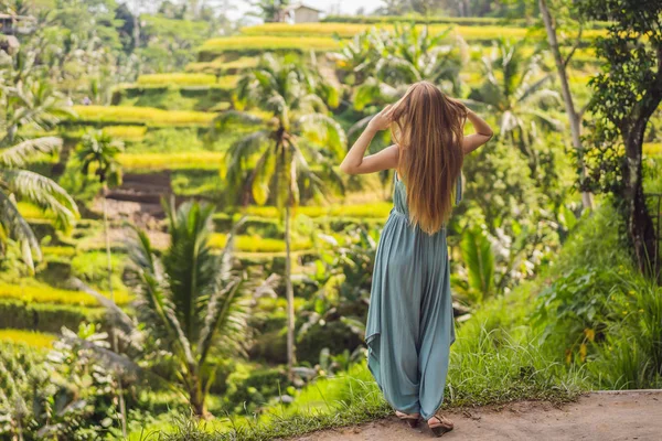 Hermosa mujer joven caminar en la ladera típica asiática con cultivo de arroz, la forma de montaña verde cascada campos de arroz terrazas arrozales. Ubud, Bali, Indonesia. Concepto de viaje Bali —  Fotos de Stock