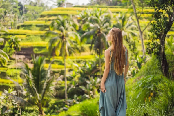 Hermosa mujer joven caminar en la ladera típica asiática con cultivo de arroz, la forma de montaña verde cascada campos de arroz terrazas arrozales. Ubud, Bali, Indonesia. Concepto de viaje Bali —  Fotos de Stock