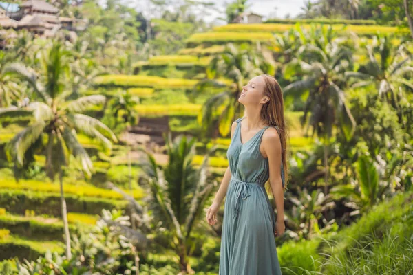 Beautiful young woman walk at typical Asian hillside with rice farming, mountain shape green cascade rice field terraces paddies. Ubud, Bali, Indonesia. Bali travel concept — Stock Photo, Image