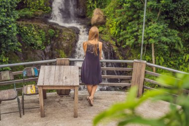 Şelale önünde duran genç bir kadın. Şelale görünümlü kadın turist