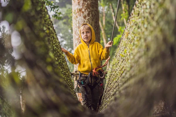 Kleine jongen in een touwenpark. Actieve fysieke recreatie van het kind in de frisse lucht in het park. Opleiding voor kinderen — Stockfoto