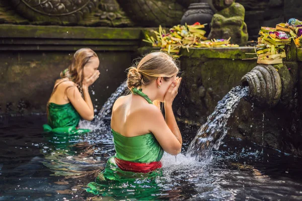 Duas mulheres no templo de água benta em Bali. O composto do templo consiste em uma estrutura petirtaan ou de banho, famosa para sua água benta da mola — Fotografia de Stock