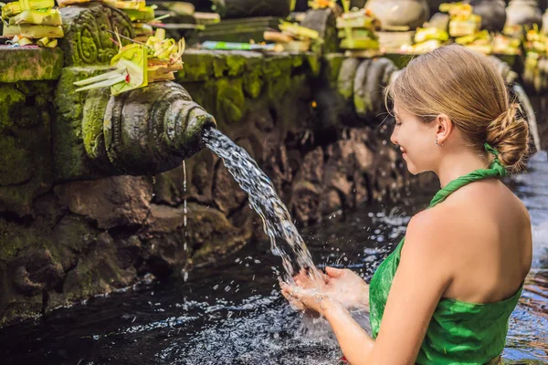 Vrouw in Heilige voorjaar water tempel in bali. De tempel compound bestaat uit een petirtaan of structuur, beroemd om zijn heilige bronwater Baden — Stockfoto