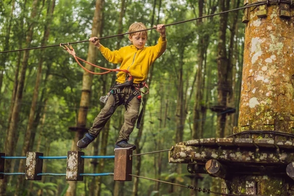 Kleine jongen in een touwenpark. Actieve fysieke recreatie van het kind in de frisse lucht in het park. Opleiding voor kinderen — Stockfoto