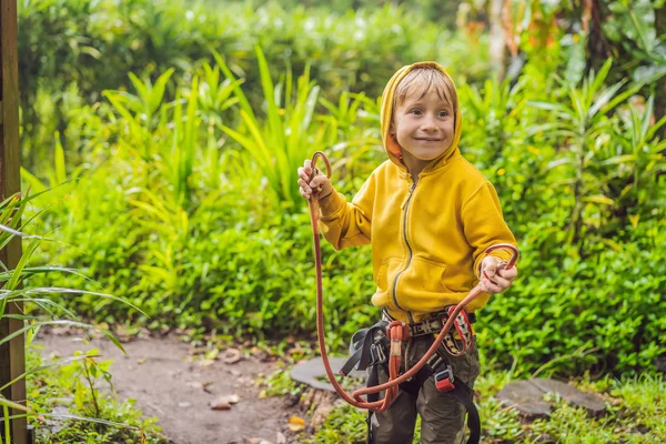 Un niño en un parque de cuerdas. Recreación física activa del niño al aire libre en el parque. Formación para niños — Foto de Stock