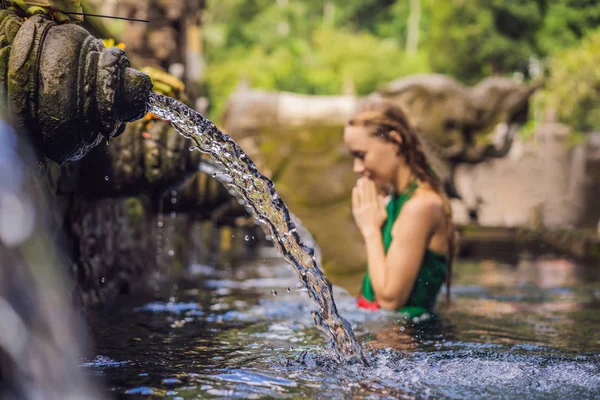 Vrouw in Heilige voorjaar water tempel in bali. De tempel compound bestaat uit een petirtaan of structuur, beroemd om zijn heilige bronwater Baden — Stockfoto