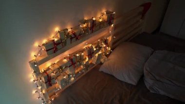 Slowmotion Noel ışıkları ile aydınlatılmış bir yatakta asılı bir geliş takvimi vurdu. Noel ve yeni yıl konsepti için hazırlanıyor. Advent takvim kavramı