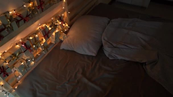 Tiro de câmera lenta de um calendário de advento pendurado em uma cama que é iluminada com luzes de Natal. Preparando-se para o Natal e Ano Novo conceito. Conceito de calendário de advento — Vídeo de Stock