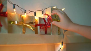 Slowmotion küçük bir çocuk çekim Noel ışıkları ile aydınlatılmış bir yatakta asılı bir geliş takvimden bir hediye alır. Noel ve yeni yıl konsepti için hazırlanıyor. Advent takvimi