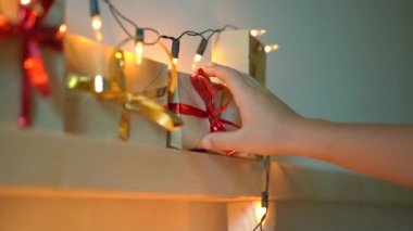 Slowmotion küçük bir çocuk çekim Noel ışıkları ile aydınlatılmış bir yatakta asılı bir geliş takvimden bir hediye alır. Noel ve yeni yıl konsepti için hazırlanıyor. Advent takvimi