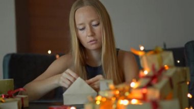 Genç bir kadın hediye paketi. Büyük tatillerden önce bu kadar çok hediye yapmaktan bıkmış. Noel ve yeni yıl yorgunluk kavramı