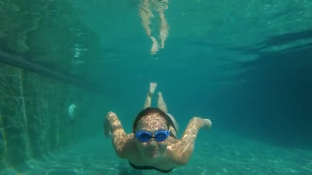 Fotografía submarina en cámara lenta de una mujer feliz buceando en una piscina. concepto de estilo de vida saludable — Vídeo de stock
