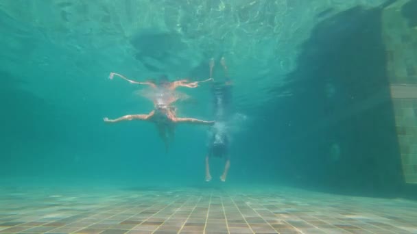 Slowmotion plan sous-marin d'un couple heureux femme et homme plonger dans une piscine. Ils dansent sous l'eau. 0 Mode de vie sain, personnes actives — Video