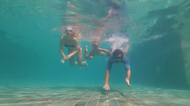Slowmotion víz alatti lövés egy boldog családi búvárkodás egy uszoda. Egészséges életmód, aktív szülők — Stock videók