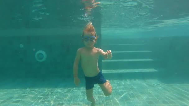 Slowmotion undervattens skott av en lycklig unge ha kul i en swimmingpool. Sunt livsstilskoncept — Stockvideo