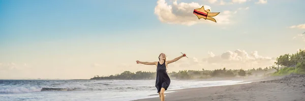 Una giovane donna lancia un aquilone sulla spiaggia. Sogno, aspirazioni, progetti futuri BANNER, FORMATO LUNGO — Foto Stock