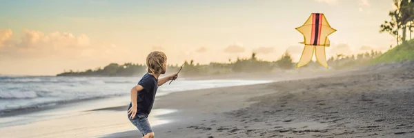 Glücklicher kleiner Junge fliegt Drachen am Strand bei Sonnenuntergang Banner, Langformat — Stockfoto