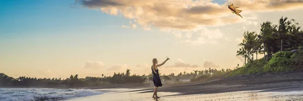 Uma jovem mulher lança um papagaio na praia. Sonho, aspirações, planos futuros BANNER, LONG FORMAT — Fotografia de Stock