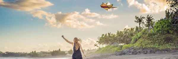 Una giovane donna lancia un aquilone sulla spiaggia. Sogno, aspirazioni, progetti futuri BANNER, FORMATO LUNGO — Foto Stock