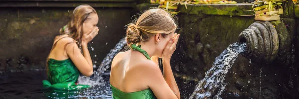 Deux femmes dans le temple de l'eau de source sainte à Bali. Le complexe du temple se compose d'un petirtaan ou structure de baignade, célèbre pour sa bannière d'eau de source sainte, FORMAT LONG — Photo