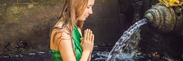 Femme dans le temple de l'eau de source sainte à Bali. Le complexe du temple se compose d'un petirtaan ou structure de baignade, célèbre pour sa bannière d'eau de source sainte, FORMAT LONG — Photo