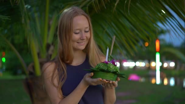 Fotografía en cámara lenta de una hermosa joven sosteniendo un krathong en sus manos celebrando una fiesta de Loi Krathong en Tailandia — Vídeos de Stock