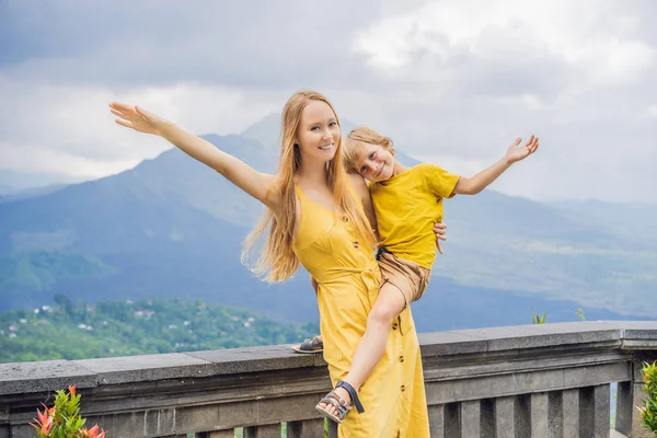 Mom and son tourists on background looking at Batur volcano. Indonesia. Traveling with kids concept — Stock Photo, Image