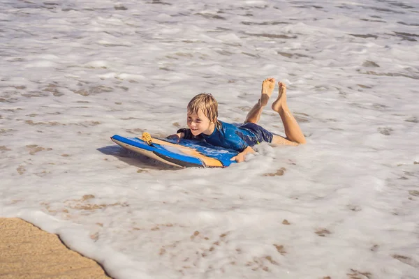 浜の休暇は、ブギー ボード上で楽しんで幸せな少年 — ストック写真