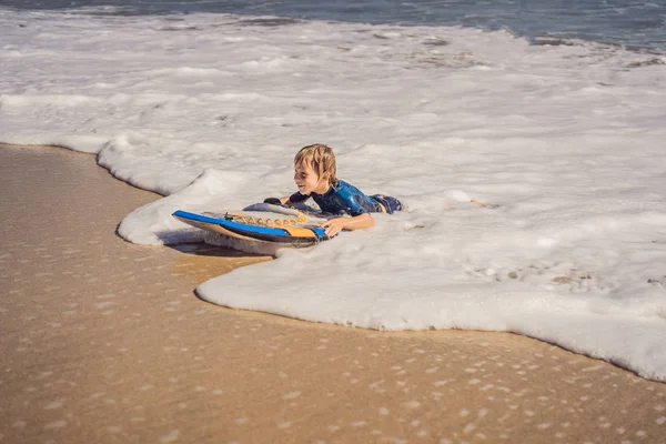 浜の休暇は、ブギー ボード上で楽しんで幸せな少年 — ストック写真