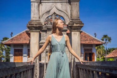 Endonezya Bali Adası'nda Su Sarayı Soekasada Taman Ujung Harabeleri elbiseli genç kadın. İnanılmaz eski mimari. Seyahat ve tatil arka plan