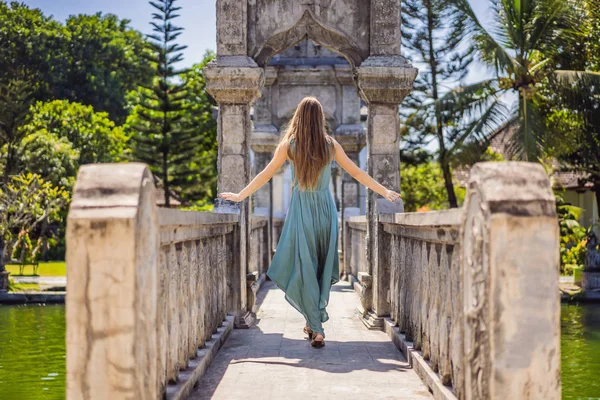 Junge Frau im Gewand im Wasserpalast soekasada taman ujung ruinen auf bali insel in indonesien. erstaunliche alte Architektur. Hintergrund zu Reise und Urlaub — Stockfoto