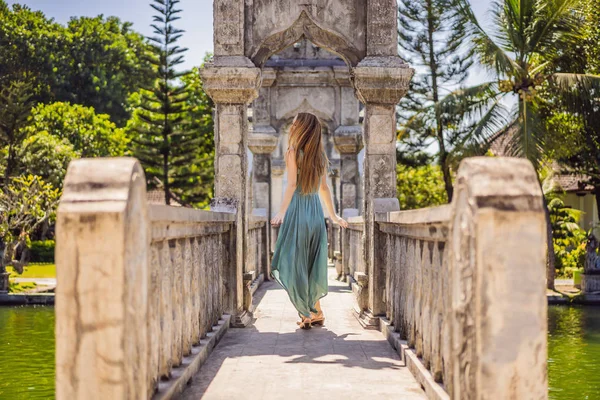Young woman in dress in Water Palace Soekasada Taman Ujung Ruins on Bali Island in Indonesia. Amazing old architecture. Travel and holidays background — Stock Photo, Image