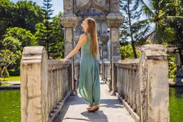 Young woman in dress in Water Palace Soekasada Taman Ujung Ruins on Bali Island in Indonesia. Amazing old architecture. Travel and holidays background — Stock Photo, Image