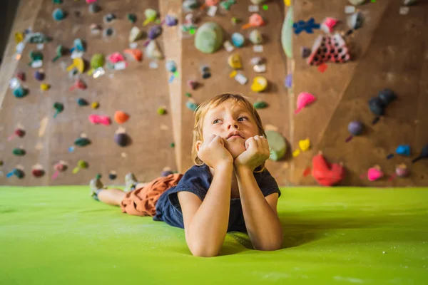 Niño descansando después de escalar una pared de roca interior —  Fotos de Stock