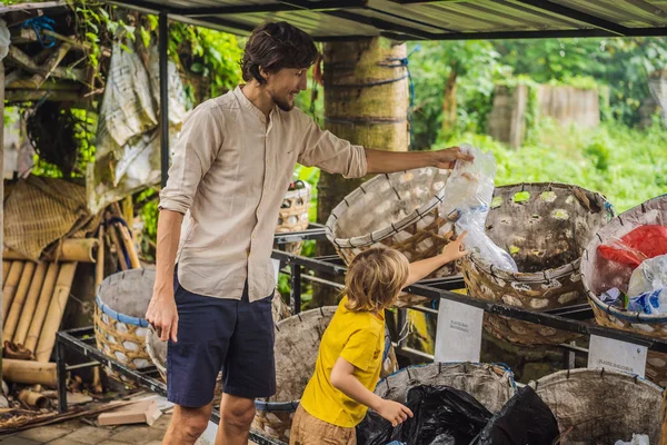 Papá e hijo, recogen basura por separado. Enseñar a los niños a separar la recolección de basura —  Fotos de Stock