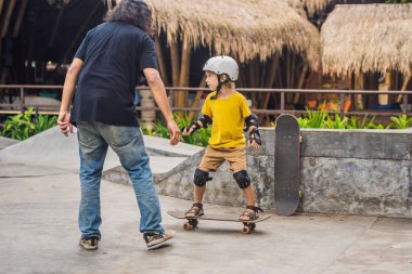 Atletik çocuk bir paten parkı bir eğitmen ile kaykay öğrenir. Çocuk eğitimi, spor