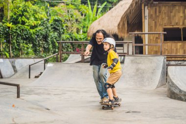 Atletik çocuk bir paten parkı bir eğitmen ile kaykay öğrenir. Çocuk eğitimi, spor