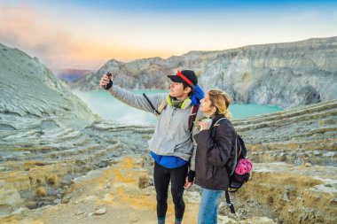 Genç turist adam ve kadın Endonezya dilinde Ijen yanardağ veya Kawah Ijen krater kenarında durmak. Dünyanın en büyük asit göl ve kükürt madenciliği içeren ünlü yanardağ