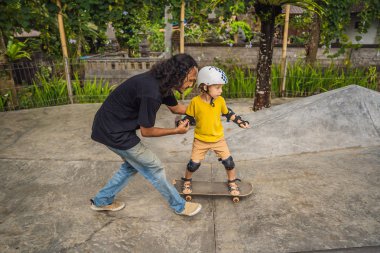 Atletik çocuk bir paten parkı bir eğitmen ile kaykay öğrenir. Çocuk eğitimi, spor