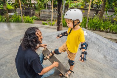Atletik çocuk bir paten parkı bir eğitmen ile kaykay öğrenir. Çocuk eğitimi, spor