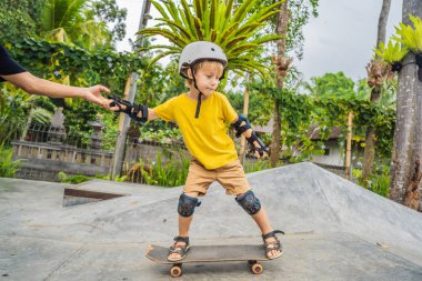 Atletik çocuk bir paten parkı bir eğitmen ile kaykay öğrenir. Çocuk eğitimi, spor