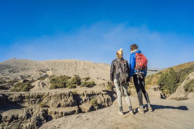 Genç çift erkek ve kadın Java Adası'nda Tengger Semeru Milli Parkı'nda Bromo yanardağı ziyaret, Endonezya. Onlar Bromo veya Gunung Bromo Endonezya, Semeru ve muhteşem görünümü zevk