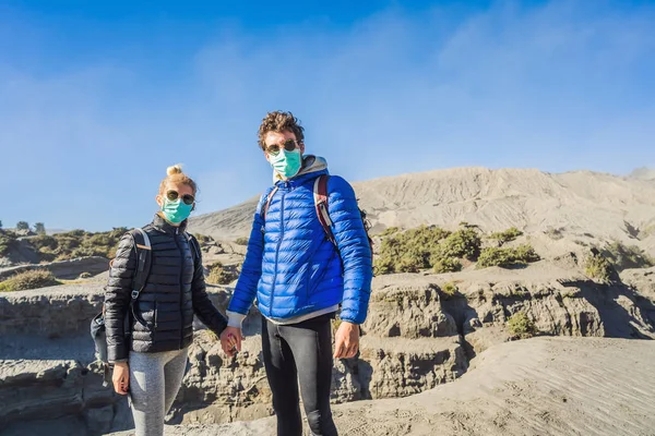 Young couple man and woman visit the Bromo volcano at the Tengger Semeru National Park on Java Island, Indonesia. They enjoy the magnificent view on the Bromo or Gunung Bromo on Indonesian, Semeru and — Stock Photo, Image