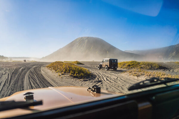 View from inside of an offroad car riding through the so-called Sea of sand inside the Tengger caldera at the Bromo Tengger Semeru National Park in the Java Island, Indonesia. One of the most famous
