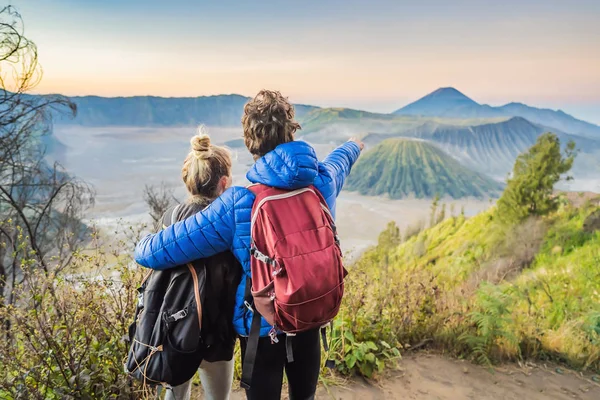 Genç çift erkek ve kadın Java Adası'nda Bromo Tengger Semeru Milli Parkı'nda gün doğumu karşılamak, Endonezya. Onlar Bromo veya Gunung Bromo Endonezya, Semeru ve muhteşem görünümü zevk — Stok fotoğraf