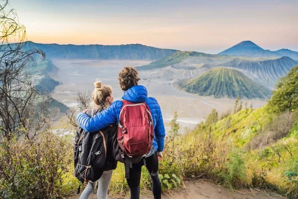 Genç çift erkek ve kadın Java Adası'nda Bromo Tengger Semeru Milli Parkı'nda gün doğumu karşılamak, Endonezya. Onlar Bromo veya Gunung Bromo Endonezya, Semeru ve muhteşem görünümü zevk — Stok fotoğraf