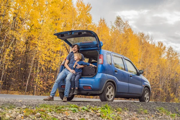 Papá e hijo están descansando al lado de la carretera en un viaje por carretera. Viaje por carretera con concepto de niños — Foto de Stock