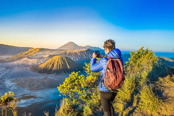 Young Man ontmoet de zonsopgang in het Bromo Tengger Semeru National Park op het Java-eiland, Indonesië. Hij geniet van een prachtig uitzicht op de Bromo of Gunung Bromo op Indonesische, Semeru en andere vulkanen — Stockfoto