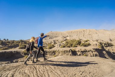 Genç çift erkek ve kadın Java Adası'nda Tengger Semeru Milli Parkı'nda Bromo yanardağı ziyaret, Endonezya. Onlar Bromo veya Gunung Bromo Endonezya, Semeru ve muhteşem görünümü zevk
