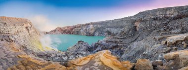 Endonezya dilinde Ijen yanardağ veya Kawah Ijen panoramik çekim. Volkanik gazların geldiği yerde dünyanın en büyüğü olan asit gölü ve sülfür madenciliği noktasını içeren ünlü yanardağ